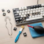 A flat-lay photo of keyboard maintenance tools arranged neatly on a desk. A partially disassembled keyboard is surrounded by a keycap puller, brush, and air blower, representing a guide to cleaning and customization.